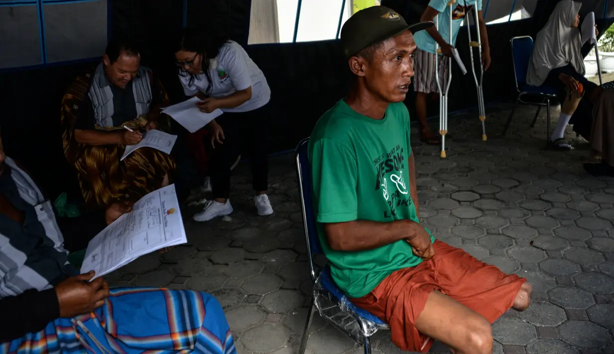 Seorang pria menunggu petugas melakukan pengukuran dan pencetakan kaki palsu di kantor Dinas Sosial Aceh, Senin (16/9/2019). Untuk tahun 2019 ini diberikan secara gratis sebanyak 100 kaki dan tangan palsu untuk para penyandang disabilitas di sejumlah kabupaten/kota. (CHAIDEER MAHYUDDIN / AFP)