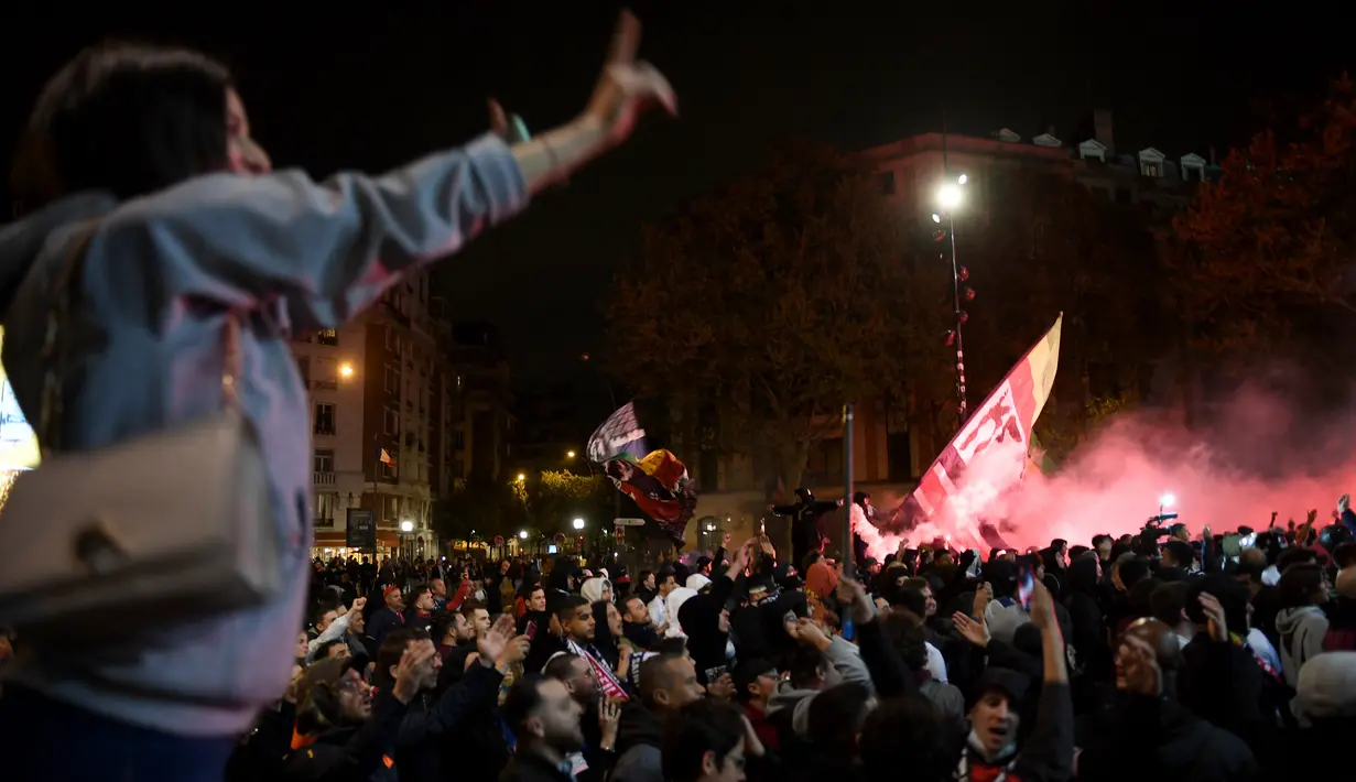 <p>Suporter Paris Saint-Germain (PSG) merayakan gelar Ligue 1 Prancis klub mereka pada akhir laga pekan ke-34 Ligue 1 kontra Lens di luar Parc des Princes, Minggu (24/4/2022) dini hari WIB. PSG juarai Liga Prancis untuk ke-10 kali meski ditahan seri Lens 1-1. (JULIEN DE ROSA / AFP)</p>