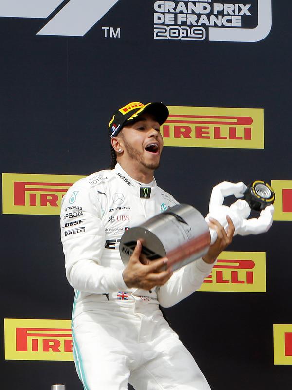 Ekspresi pebalap Mercedes Lewis Hamilton saat memegang trofi juara setelah menjuarai F1 GP Prancis 2019 di Sirkuit Paul Ricard, Minggu (23/6/2019). Hamilton tampil dominan dan menjadi juara F1 GP Prancis 2019. (AP Photo/Claude Paris)