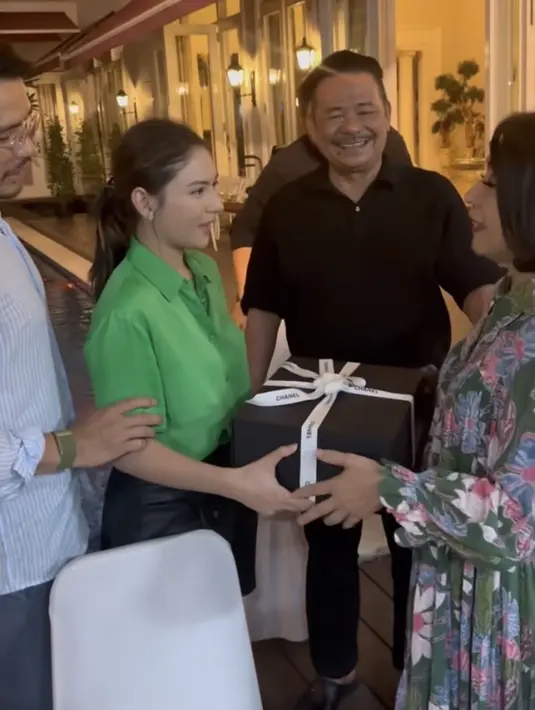 Jessica Mila pun terlihat menerima hadiah dari mamah mertua tersebut. Terlihat Jessica mengenakan atasan kemeja hijau dan celana short pants hitam. [Instagram/@pettyhasibuan]