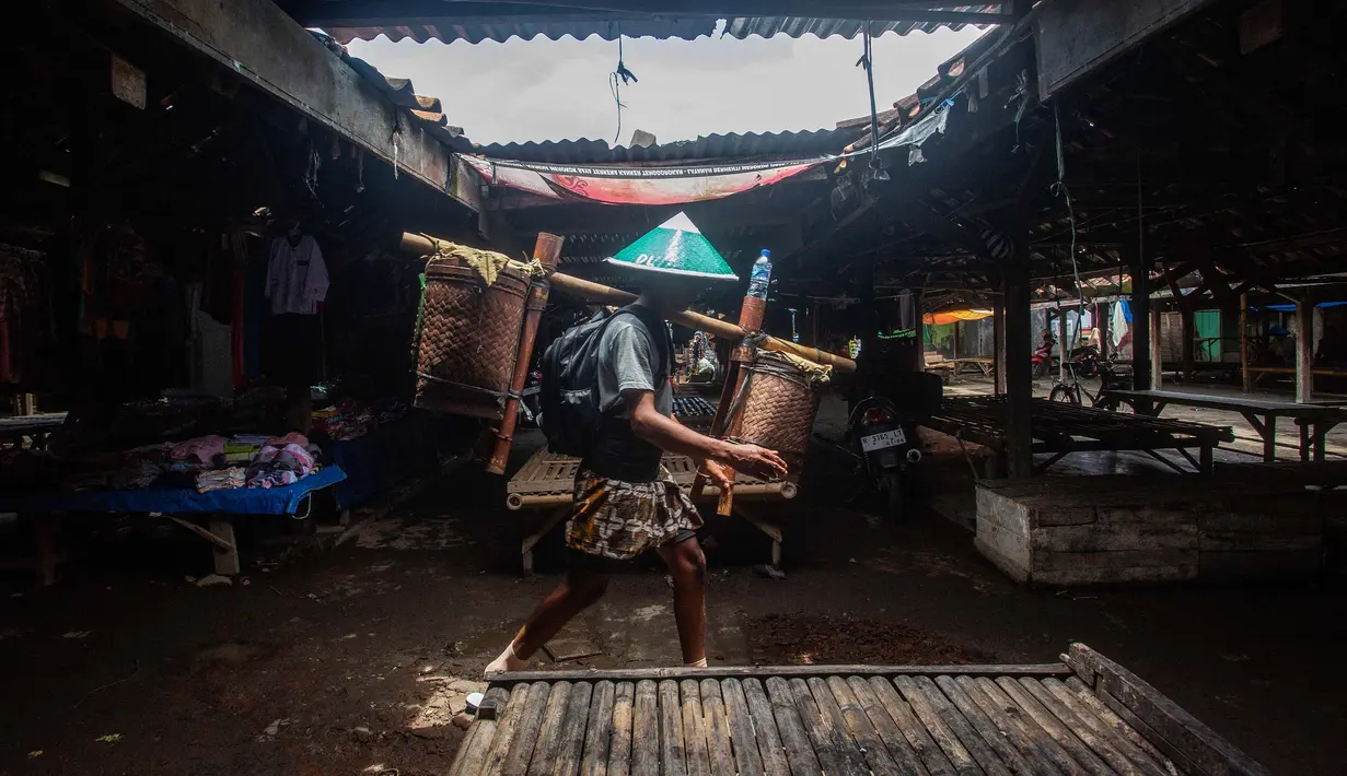 Seorang pria dari masyarakat adat Bonokeling berjalan melewati pasar selama prosesi tradisi Unggah-unggahan di Banyumas, Jawa Tengah, pada 20 Februari 2025. (DEVI RAHMAN/AFP)