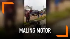 Geram karena mencoba kabur usai terciduk mencuri motor, warga melempar maling ke kali penuh lumpur.