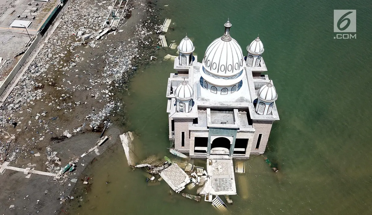 Pandangan udara Masjid Terapung Arqam Bab Al Rahman pasca gempa dan tsunami Palu di Pantai Talise, Sulawesi Tengah. Bangunan masjid yang terletak di pinggir pantai terlihat utuh meski sebagian bangunannya tenggelam. (Liputan6.com/Fery Padolo)