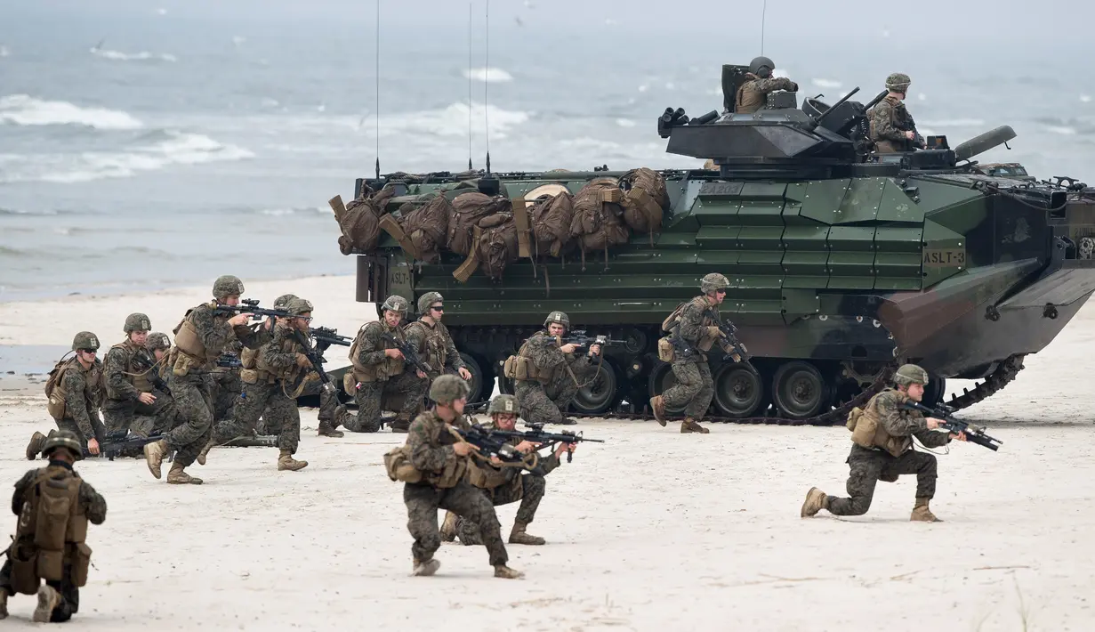 Pasukan marinir AS bersenjata lengkap melakukan operasi pendaratan saat latihan militer Baltops 2018 di Laut Baltik, Lithuania (4/6). (AP/Mindaugas Kulbis)