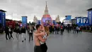 Suporter Rusia berciuman saat berada di Fan Fest Piala Dunia Moskow, Minggu (10/6/2018). Sepenggal kisah romantis saat Piala Dunia 2018 Rusia. (AFP/Dimitar Dilkoff)
