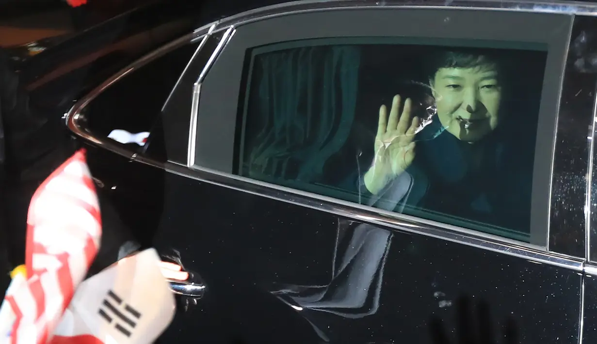 Mantan Presiden Korea Selatan (Korsel) Park Geun-hye melambaikan tangan dari dalam mobil setibanya di rumah pribadinya di Seoul, Minggu (12/3). Geun-hye meninggalkan Blue House setelah resmi dimakzulkan Mahkamah Konstitusi (MK) Korsel. (str/YONHAP/AFP)