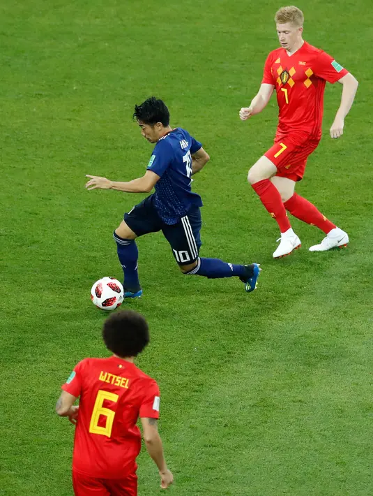 Pemain timnas Jepang, Shinji Kagawa menggiring bola dnegan kawalan pemain Belgia Kevin De Bruyne dan Axel Witsel pada 16 besar Piala Dunia 2018 di Rostov Arena, Selasa (3/7). Belgia lolos ke perempat final setelah mengalahkan Jepang 3-2. (AP/Hassan Ammar)