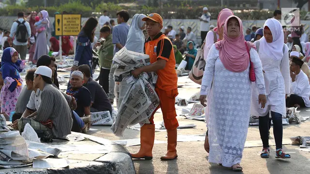 Melihat Kesigapan Petugas Kebersihan Punguti Sisa Koran Salat Id