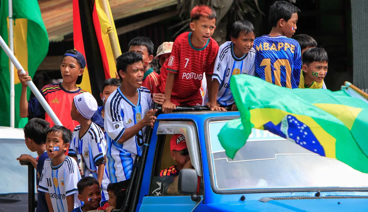 Penggemar sepak bola berpartisipasi dalam konvoi menyambut turnamen sepak bola Piala Dunia 2026 di Polewali Mandar, Sulawesi Barat, Kamis 11 Juni 2026. (Muhammad SALIM/AFP)