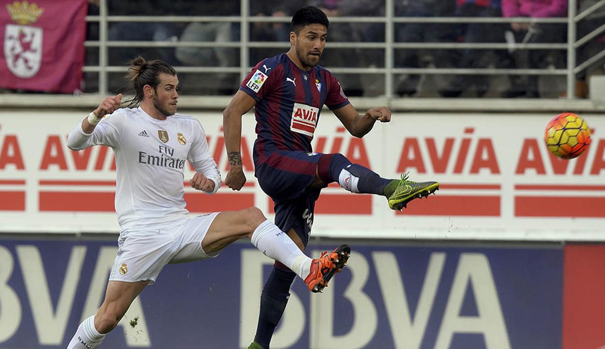 Pemain Real Madrid, Gareth Bale, berebut bola dengan pemain Eibar, Mauro Dos Santos, pada laga Liga Spanyol di Estadio Municipal de Ipurua, Spanyol, Minggu (29/11/2015). (Reuters/Vincent West) 