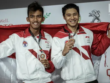 Perenang Indonesia Glenn Victor Sutanto (kanan), Triady Fauzi Sidiq (kanan) menunjukan medali usai bertanding di SEA Games 2017 di National Aquatic Centre, Bukit Jalil, Malaysia, Rabu (23/8). (Liputan6.com/Faizal Fanani)