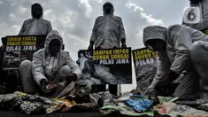 Aktivis membawa poster saat aksi "Sampah Impor Bunuh Sungai Pulau Jawa" di kawasan Patung Kuda, Monas, Jakarta, Senin (3/5/2021). Aktivis tergabung dalam Ecoton dan Forkadas (Forum Komunitas Daerah Aliran Sungai Citarum, Ciujung, serta Ciliwung Institut). (merdeka.com/Iqbal S. Nugroho)