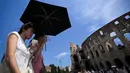 Orang-orang melindungi diri dari terik matahari dengan payung di dekat Koloseum selama gelombang panas awal musim di Roma pada Kamis 28 Mei 2026. (Tiziana FABI/AFP)