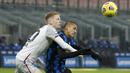 Striker Inter Milan, Alexis Sanchez (kanan), berebut bola dengan gelandang Bologna, Jerdy Schouten dalam laga lanjutan Liga Italia Serie A pekan ke-9 di San Siro Stadium, Sabtu (5/12/2020). Inter milan mengalahkan Bologna 3-1. (AP/Antonio Calanni)