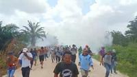 Warga Desa Gondai, Kabupaten Pelalawan, berlarian menghindari tembakan gas air mata di lokasi eksekusi lahan. (Liputan6.com/M Syukur)