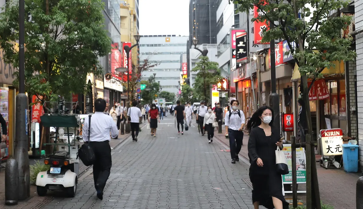 Orang-orang yang mengenakan masker berjalan di Minato-ku, Tokyo, Jepang (30/6/2020). Pemerintah kota metropolitan Tokyo mengonfirmasi 54 kasus infeksi baru COVID-19, menandai hari kelima berturut-turut penambahan kasus harian baru di ibu kota tersebut. (Xinhua/Du Xiaoyi)