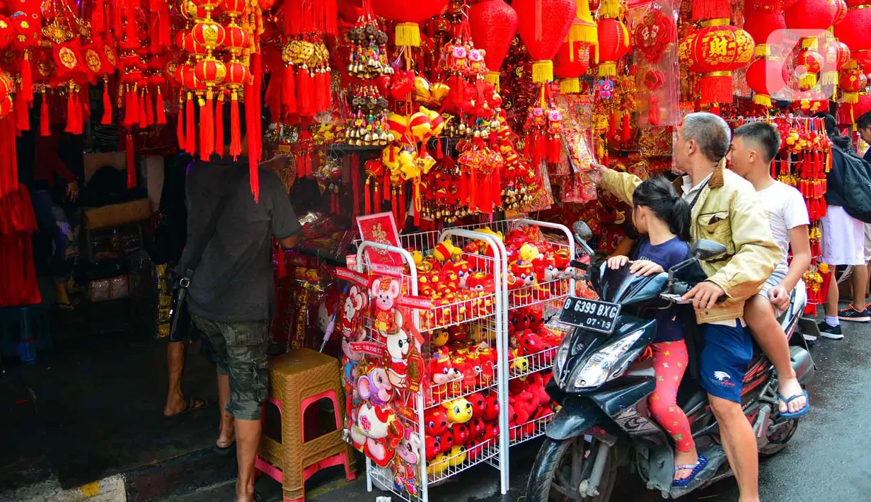 Pengendara motor melihat pernak-pernik Imlek yang dijual di kawasan Glodok, Jakarta, Senin (13/1/2020). Menyambut tahun baru Imlek pada 25 Januari mendatang, penjualan pernak-pernik imlek dijual dengan harga Rp 5ribu hingga jutaan rupiah per buah tergantung jenis. (merdeka.com/Arie Basuki)