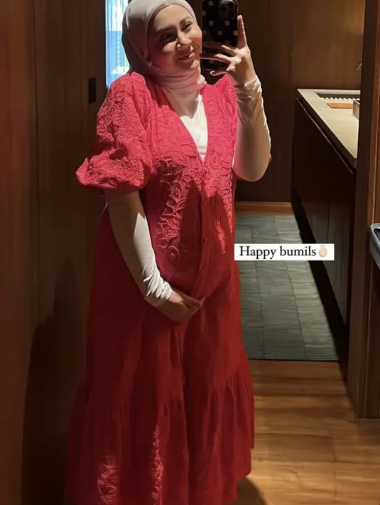 Kesha juga tampil fresh dengan maxi dress merah bordir krah vneck dan lengan pumpnya. Dipadukan manset putih serta kerudung abunya.  (@kesharatuliu05)