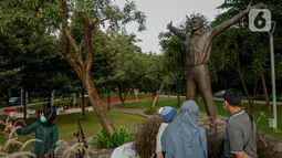 Pengunjung mengamati patung Kosmonaut Rusia, Yuri Alekseyevich Gagarin atau akrab disebut Yuri Gagarin di Taman Mataram, Kebayoran Baru, Jakarta, Minggu (14/3/2021). Kosmonaut Rusia ini adalah orang pertama yang berhasil pergi ke luar angkasa pada tahun 1961 silam. (Liputan6.com/Faizal Fanani)