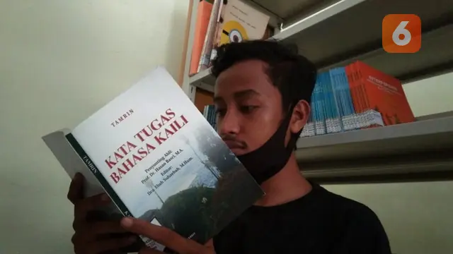 pengunjung membaca buku pengetahuan bahasa kaili di perpustakaan Balai Bahasa Sulteng