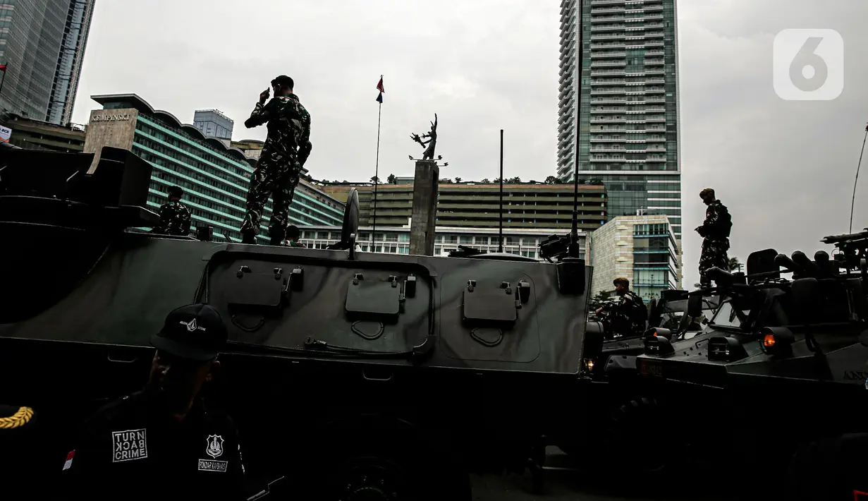 Tentara berdiri di atas alat utama sistem senjata (alutsista) milik TNI saat perayaan HUT ke-77 TNI di Bundaran HI, Jakarta, Rabu (5/10/2022). Kegiatan yang diikuti oleh seluruh kesatuan jajaran TNI ini dalam rangka menyambut HUT ke-77 TNI. (Liputan6.com/Faizal Fanani)