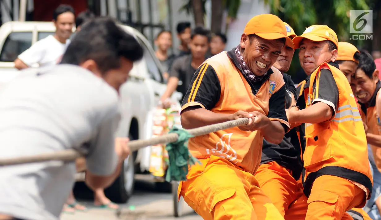 Petugas PPSU Kelurahan Kebon Sirih saat mengikuti lomba tarik tambang di kawasan Jalan Jaksa, Jakarta, Kamis (17/8). Lomba diadakan untuk memeriahkan HUT RI ke-72. (Liputan6.com/Helmi Fithriansyah)