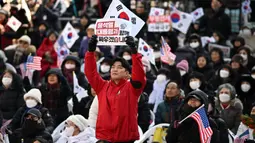 Dalam aksinya, mereka membawa poster, mengibarkan bendera Korea Selatan dan Amerika Serikat, serta bernyanyi selama unjuk rasa berlangsung. (Philip FONG/AFP)