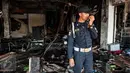 Seorang satpam mengecek keadaan kios usai terbakar di Pasar Senen, Jakarta, Jumat (20/1). Badan Penanggulangan Bencana Daerah DKI Jakarta menyatakan jumlah kios Pasar Senen sebanyak 1.691 kios. (Liputan6.com/Gempur M Surya)