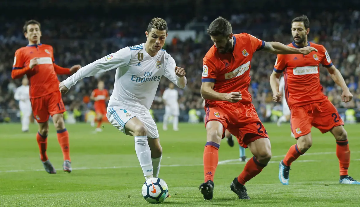 Striker Real Madrid, Cristiano Ronaldo, berusaha melewati pemain Real Sociedad, Raul Navas, pada laga La Liga di Stadion Santiago Bernabeu, Sabtu (10/2/2018). Real Madrid menang 5-2 atas Real Sociedad. (AP/Francisco Seco)