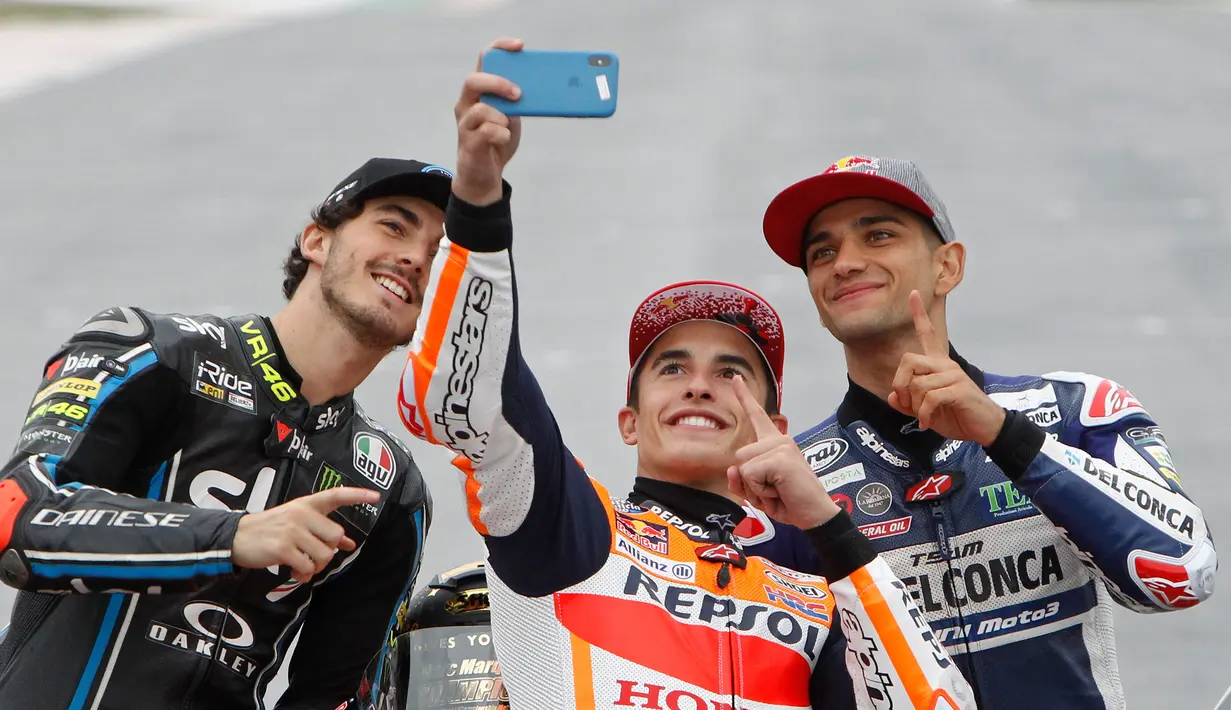 Juara Dunia MotoGP Marc Marquez (tengah) berswafoto bersama Juara Dunia Moto2 Francesco Bagnaia (kiri) dan Juara Dunia Moto3 Jorge Martin (kanan) usai Grand Prix Valencia di sirkuit Ricardo Tormo, Cheste, Spanyol, Minggu (18/11). (AP Photo/Alberto Saiz)