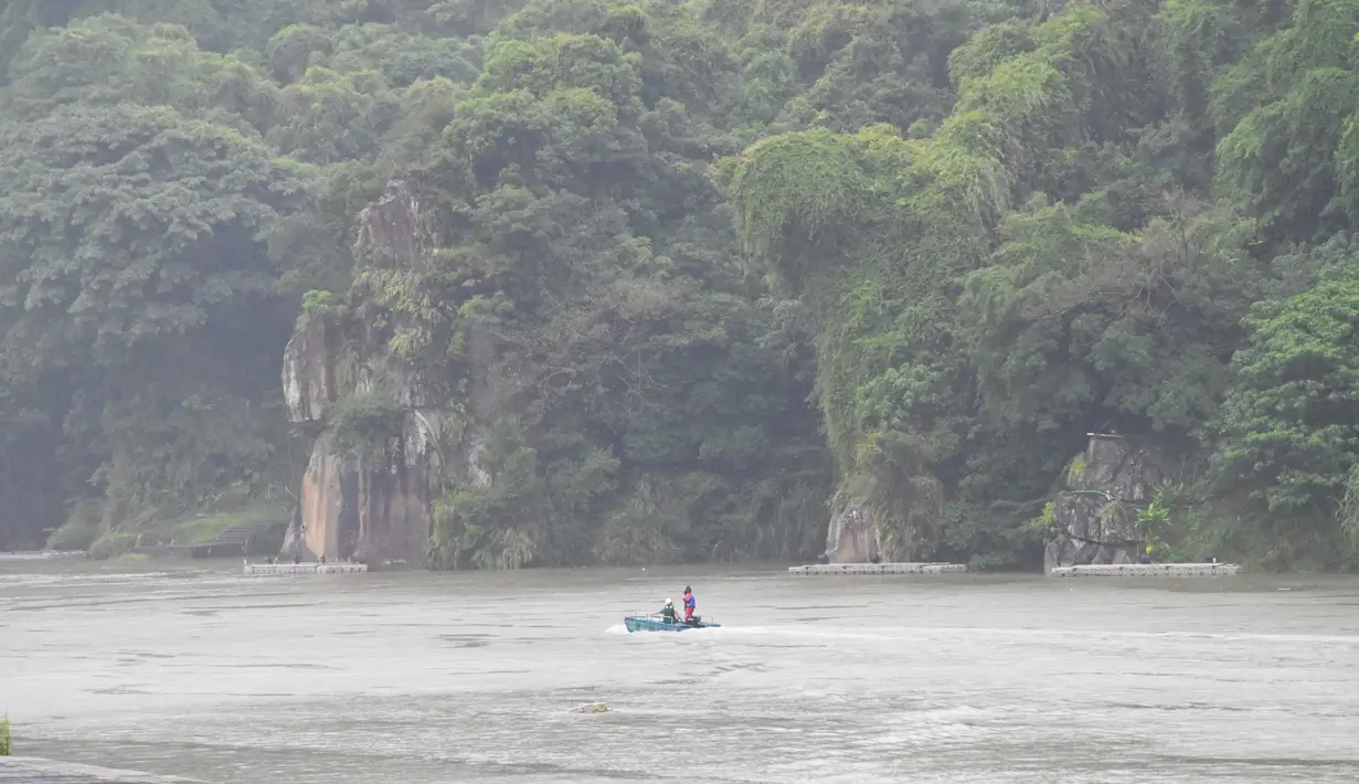 Pekerja berpatroli di Sungai Xindian di New Taipei City saat badai tropis Hinnamnor mendekati Taiwan timur (2/9/2022). Biro Cuaca Pusat (CWB) mengeluarkan peringatan darat Sabtu pagi untuk Topan Hinnamnor, yang diperkirakan akan melewati pantai timur laut Taiwan, membawa hujan lebat dan angin kencang ke New Taipei, Yilan dan Keelung. (AFP/Sam Yeh)