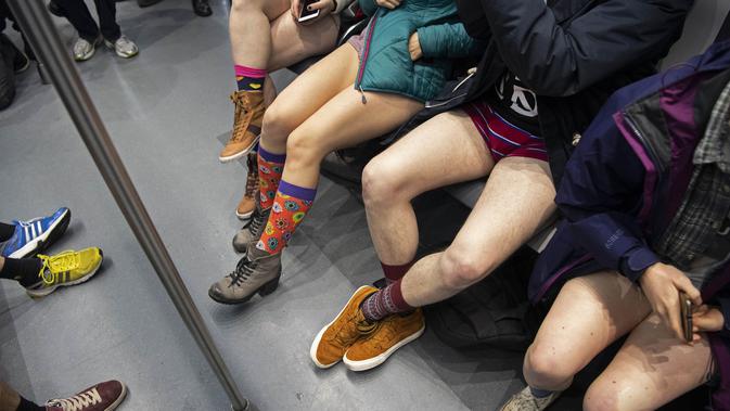 Sejumlah penumpang tanpa mengenakan celana duduk di kereta selama No Pants Subway Ride ke-18 di Amsterdam, Belanda (13/1). No Pants Subway Ride ajang tahunan yang sudah menyebar ke berbagai kota besar di dunia. (AFP Photo/Olaf Kraak)
