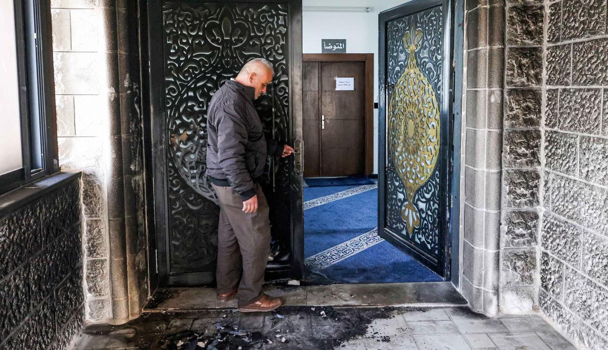 Pemukim ilegal Israel mencoret dan membakar sebuah masjid di Tepi Barat yang diduduki. Tampak dalam foto, seorang pria memeriksa pintu masuk Masjid Abu Bakr al-Siddiq di desa Tell, sebelah barat Nablus, Tepi Barat yang diduduki, pada 23 Februari 2026. (JAAFAR ASHTIYEH/AFP)