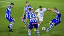 Striker Real Madrid, Karim Benzema, berusaha melewati pemain Alaves pada laga Liga Spanyol di Stadion Mendizorroza, Sabtu (23/1/2021). Real Madrid menang dengan skor 4-1. (AP/Alvaro Barrientos)