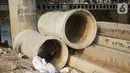 Tiang pancang dan saluran gorong-gorong menghiasi bantaran Sungai Ciliwung di kawasan Rawajati, Jakarta, Rabu (30/10/2019). Tiang-tiang pancang itu merupakan sisa proyek normalisasi Sungai Ciliwung dan telah berada di bantaran tersebut selama beberapa tahun terakhir. (Liputan6.com/Immanuel Antonius)