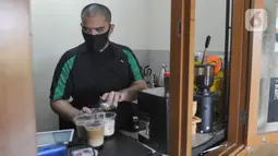 Ahmad Hilmy Almusawa meracik kopi di Mata Hati Koffie di Pamulang, Tangerang Selatan, Selasa (21/7/2020). Sejak pandemi corona ia tetap semangat berjuang mencari nafkah walau pendapatannya berkurang dari sebelum pandemi Rp 1 juta /hari kini Rp 200 hingga Rp 300 ribu/hari. (merdeka.com/Arie Basuki)