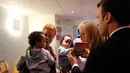 Presiden Prancis Emmanuel Macron berinteraksi dengan anak-anak saat mengunjungi Graffiti's- Association Le Moulin Vert di Normandia, Prancis (5/4). (AP / Christophe Ena, Pool)