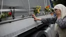 Seorang wanita menangis saat menyentuh sebuah truk yang membawa 136 peti mati korban yang baru diidentifikasi dari pembantaian Srebrenica 1995, di desa Visoko, Bosnia-Herzegovina, Kamis, (9/7/2015). (REUTERS/Stoyan Nenov) 