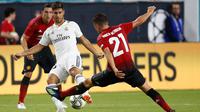 Gelandang Real Madrid Marco Asencio berusaha mengontrol bola dari kawalan pemain MU Ander Herrera saat bertanding pada International Champions Cup di Miami Gardens, Fla (31/7). MU menang tipis 2-1 atas Madrid. (AP Photo / Brynn Anderson )