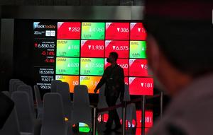 Karyawan melintasi layar yang menampilkan Indeks Harga Saham Gabungan (IHSG) saat acara Penutupan Perdagangan Bursa Efek Indonesia Tahun 2022 di Jakarta, Jumat (30/12/2022). PT Bursa Efek Indonesia (BEI) mencatat ada 59 perusahaan yang melakukan Initial Public Offering (IPO) atau pencatatan saham sepanjang 2022. Pada penutupan perdagangan akhir tahun, Indeks Harga Saham Gabungan (IHSG) ditutup lesu 0,14% atau 9,46 poin menjadi 6.850,62. (Liputan6.com/Angga Yuniar)