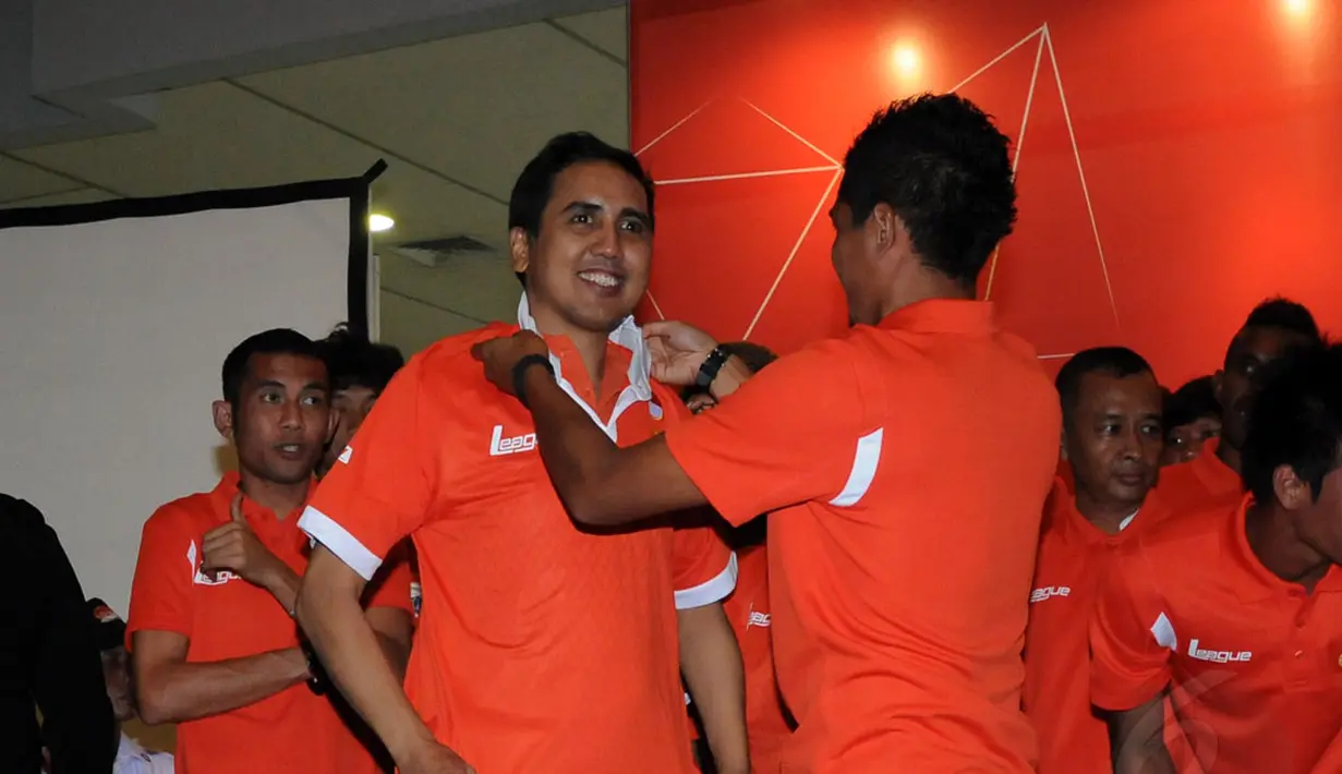 Bambang Pamungkas (kanan) memakaikan kostum baru Persija Jakarta musim 2015 kepada sesepuh JakMania, Gugun Gondrong saat acara peluncuran yang dihelat di Hall Atrium JIExpo, Kemayoran, (23/12/2014). (Liputan6.com/Helmi Fithriansyah)