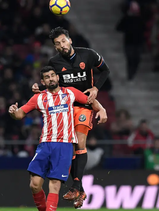 Bek Valencia Ezequiel Garay berusaha memotong bola striker Atletico Madrid Diego Costa saat pertandingan Liga Spanyol di stadion Wanda Metropolitano, Madrid (4/2). Gol tunggal Atletico Madrid diciptakan oleh Angel Correa. (AFP Photo/Gabriel Bouys)