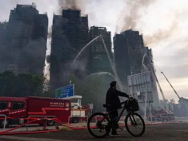 Petugas pemadam kebakaran berupaya memadamkan kebakaran yang terjadi di Wang Fuk Court, sebuah kompleks perumahan di distrik Tai Po, Wilayah Baru Hong Kong, Kamis 27 November 2025. Kebakaran dahsyat melanda Hong Kong. Setidaknya delapan gedung dan hampir 2.000 apartemen terbakar. (AP Photo/Chan Long Hei)