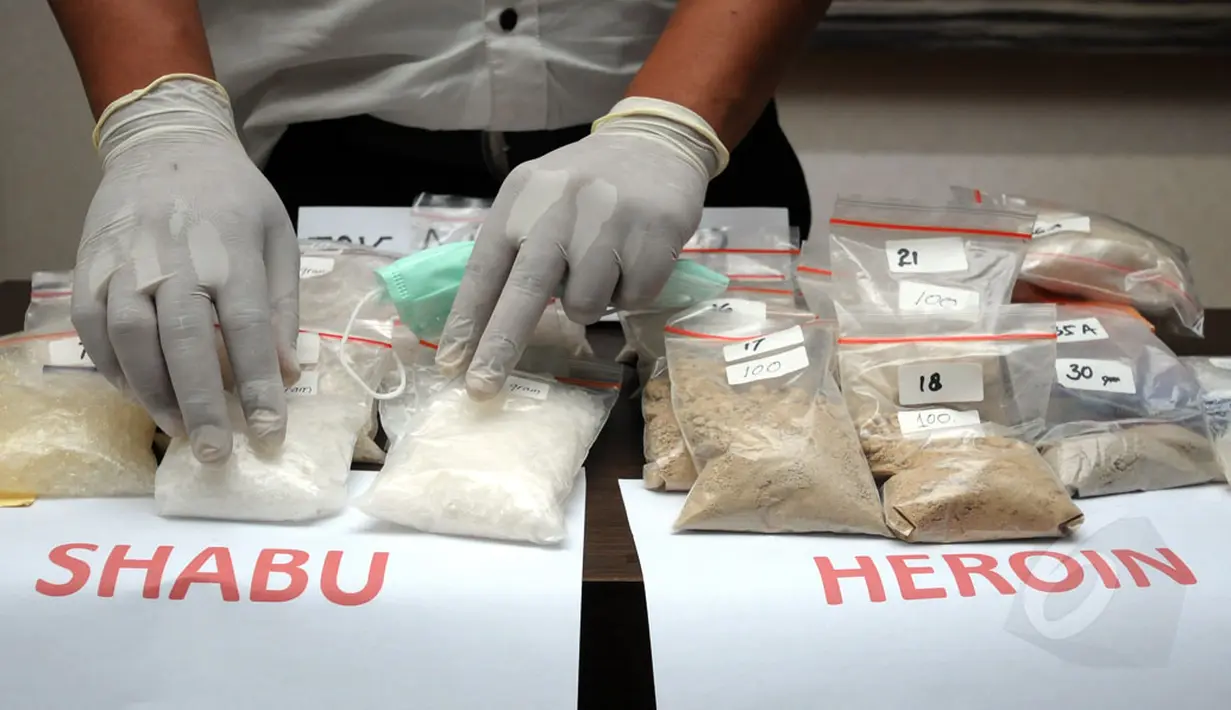 Salah satu petugas merapikan barang bukti narkotika jenis sabu saat jumpa pers di Dit Resnarkoba Polda Metro Jaya, Kamis (13/11/2014). Sebanyak 19,3 kg shabu dan 1,03 heroin disita Dit Resnarkoba Polda Metro Jaya. (Liputan6.com/Helmi Fithriansyah)