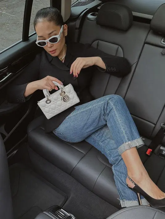 Inspirasi outfit ke kantor, sontek gaya fashion influencer Ayla Dimitri mengenakan blazer hitam, celana jeans dan Dior Small Lady D-Joy warna putih. [Dior].