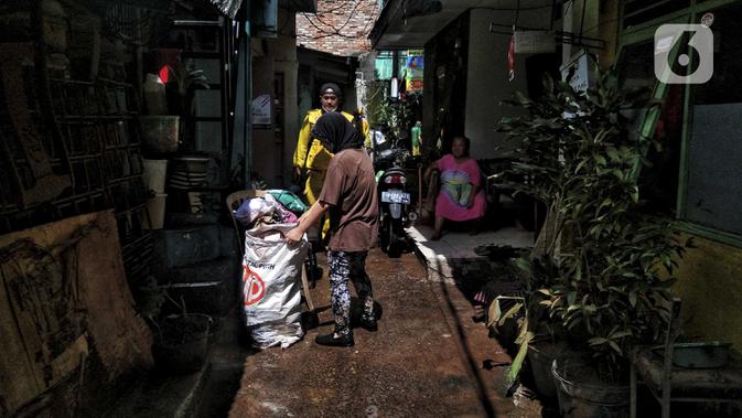 Warga membersihkan sampah sisa banjir di Kebalen, Jakarta, Minggu (21/2/2021). Banjir yang terjadi kemarin karena curah hujan yang tinggi meninggalkan sampah di rumah warga. (Liputan6.com/Johan Tallo)