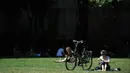 Seorang wanita bersantai di bawah sinar matahari di Victoria Tower Gardens dekat Gedung Parlemen di London, Inggris (23/7/2019). Suhu melonjak di atas 30C (86F) di Inggris pada 23 Juli dengan para peramal cuaca memperkirakan suhu setinggi 37C (96.8F) sebelum akhir pekan. (AFP Photo/Ben Stansall)