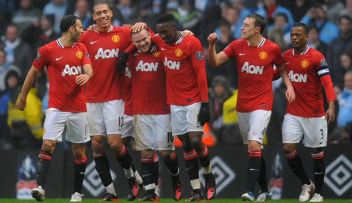 Pemain Manchester United, Wayne Rooney (ketiga kiri) melakukan selebrasi bersama rekannya setelah mencetak gol ketiga ke gawang Manchester City pada laga putaran ketiga Piala FA 2011/2012 yang berlangsung di Etihad Stadium, Manchester, 8 Januari 2012. Setan Merah menang dengan skor 3-2. (AFP/Paul Ellis)