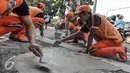 Petugas Penanganan Prasarana dan Sarana Umum (PPSU) menambal lubang jalanan di wilayah Pasar Senen, Jakarta, Selasa (26/7). Penambalan jalan berlubang ini bertujuan untuk kenyamanan pengguna jalan yang melintas. (Liputan6.com/Yoppy Renato)