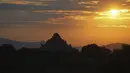 Siluet kuil kuno saat matahari terbenam di Bagan, distrik Nyaung U, Myanmar tengah, Rabu (8/12/2021). Bagan merupakan salah satu kota dari Kerajaan Pagan, yang memiliki 10.000 kuil Buddha. (AP Photo)